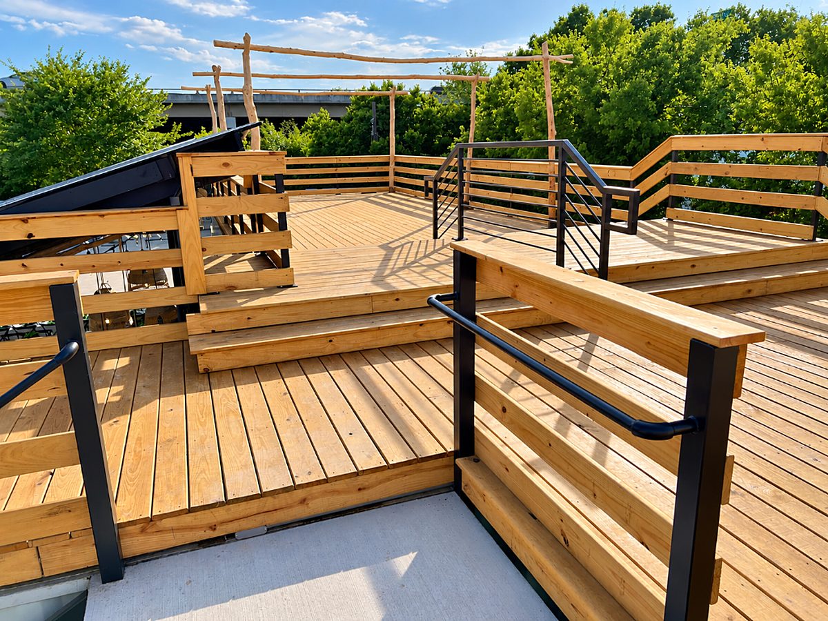 Wooden rooftop deck with railings built by Texas 1st Services